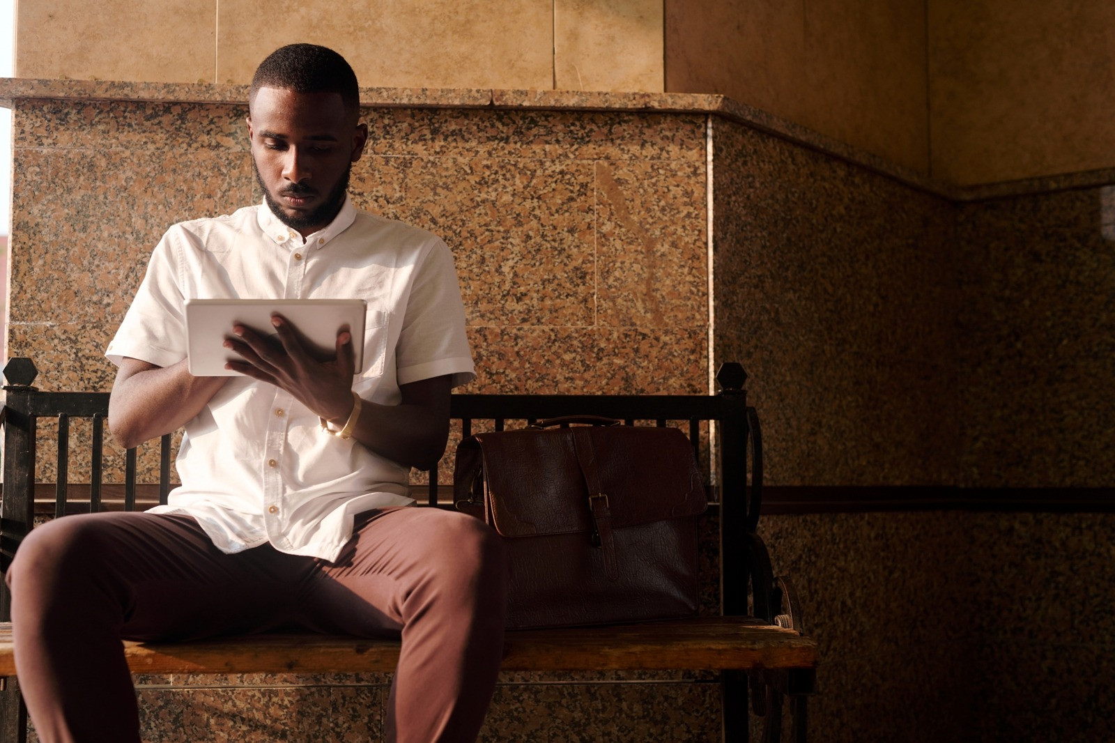 Man using a tablet while seated indoors, representing a beginner exploring self-guided EMDR.
