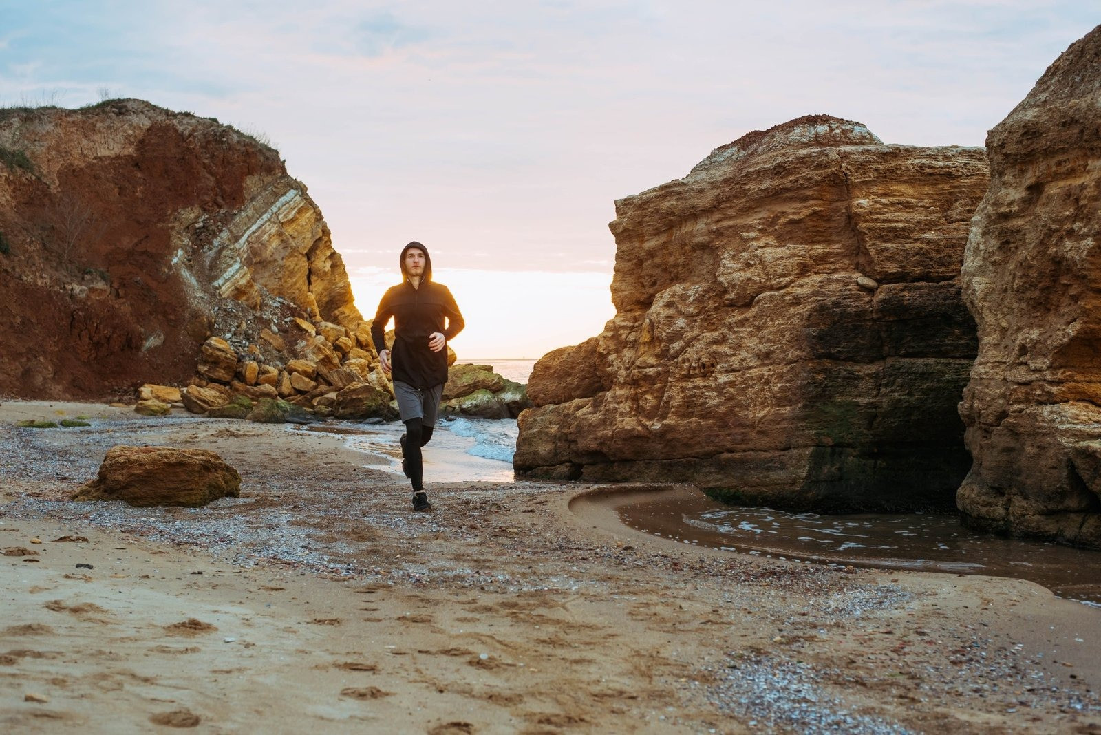 Man running outdoors along a rocky beach