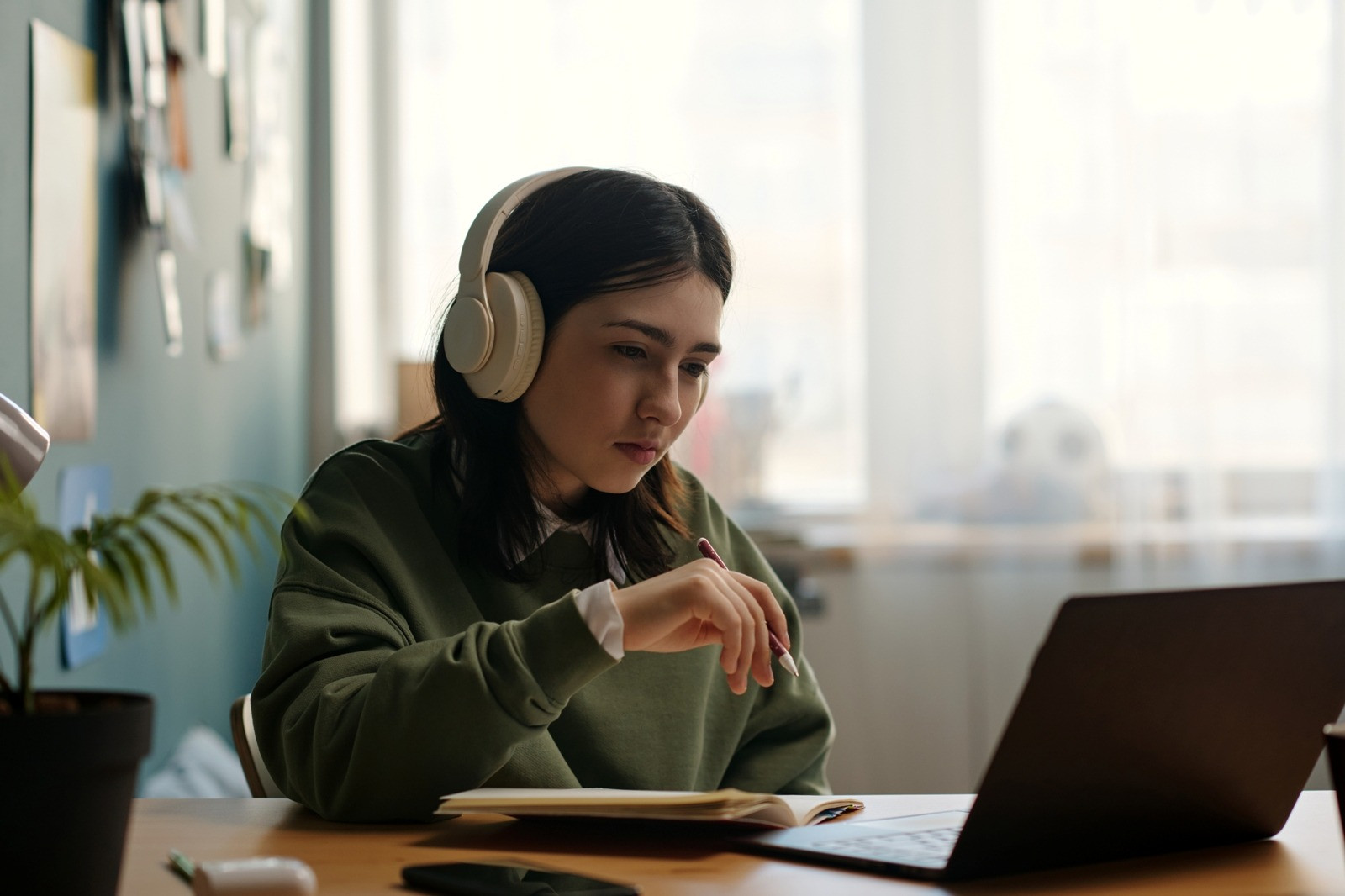 Woman wearing headphones and using a laptop while practicing EMDR resourcing techniques at home