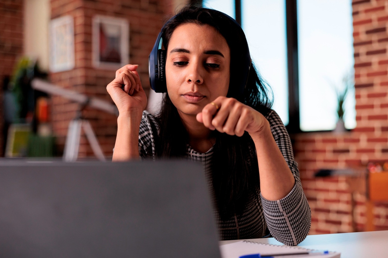Woman wearing headphones during a self-guided EMDR session at home using a laptop