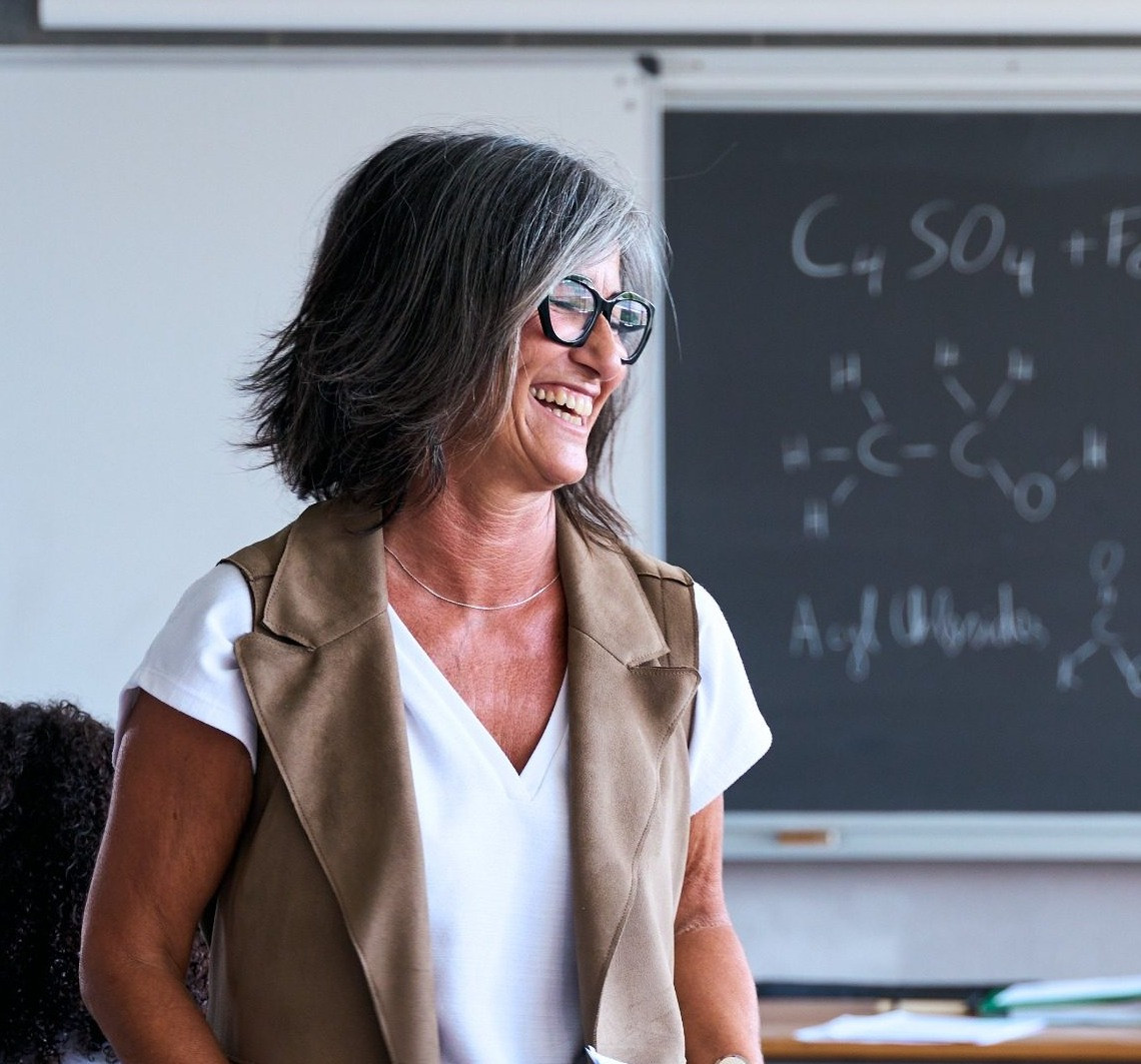 Smiling teacher standing in a classroom