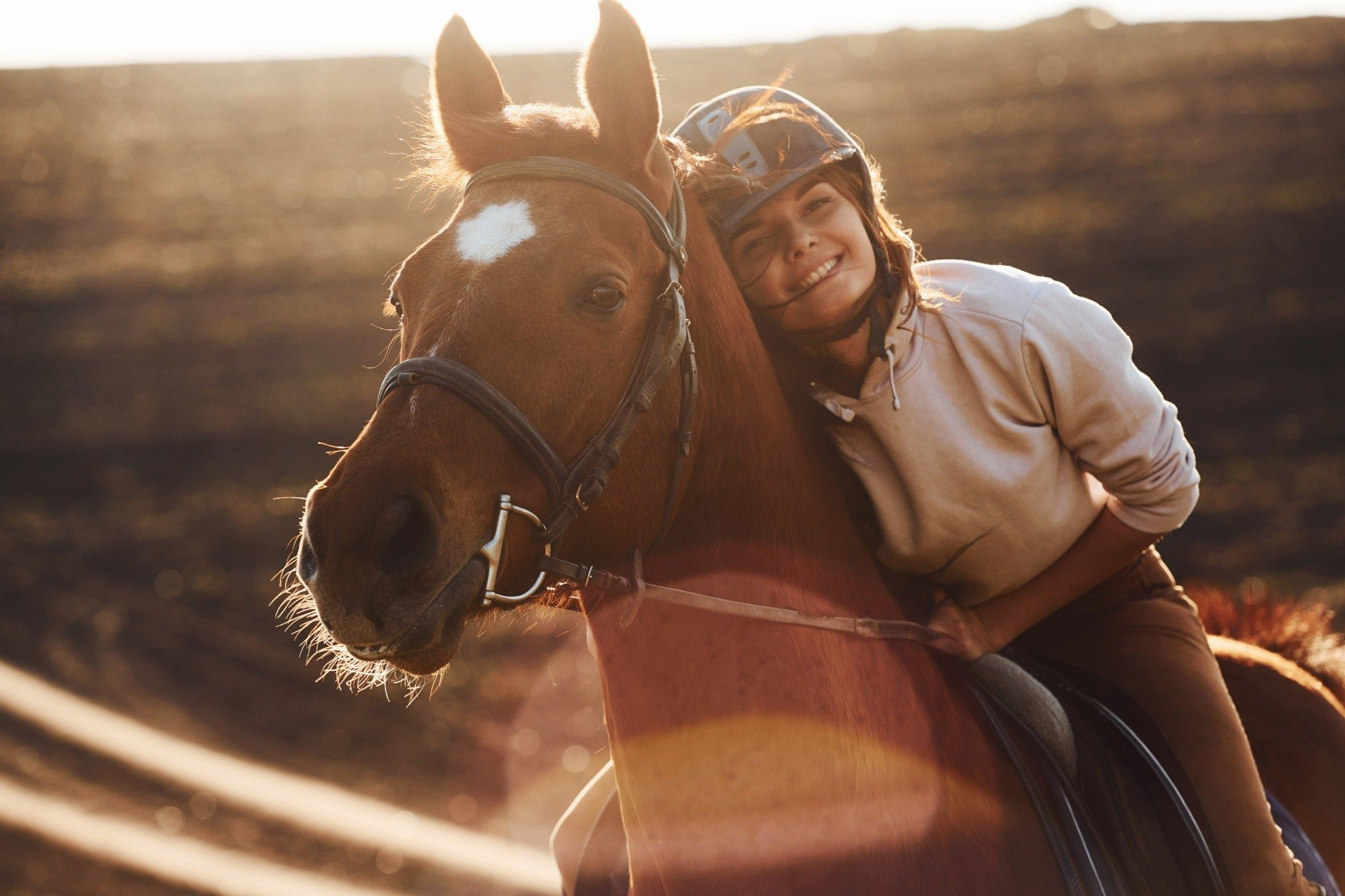Woman smiling beside a horse outdoors