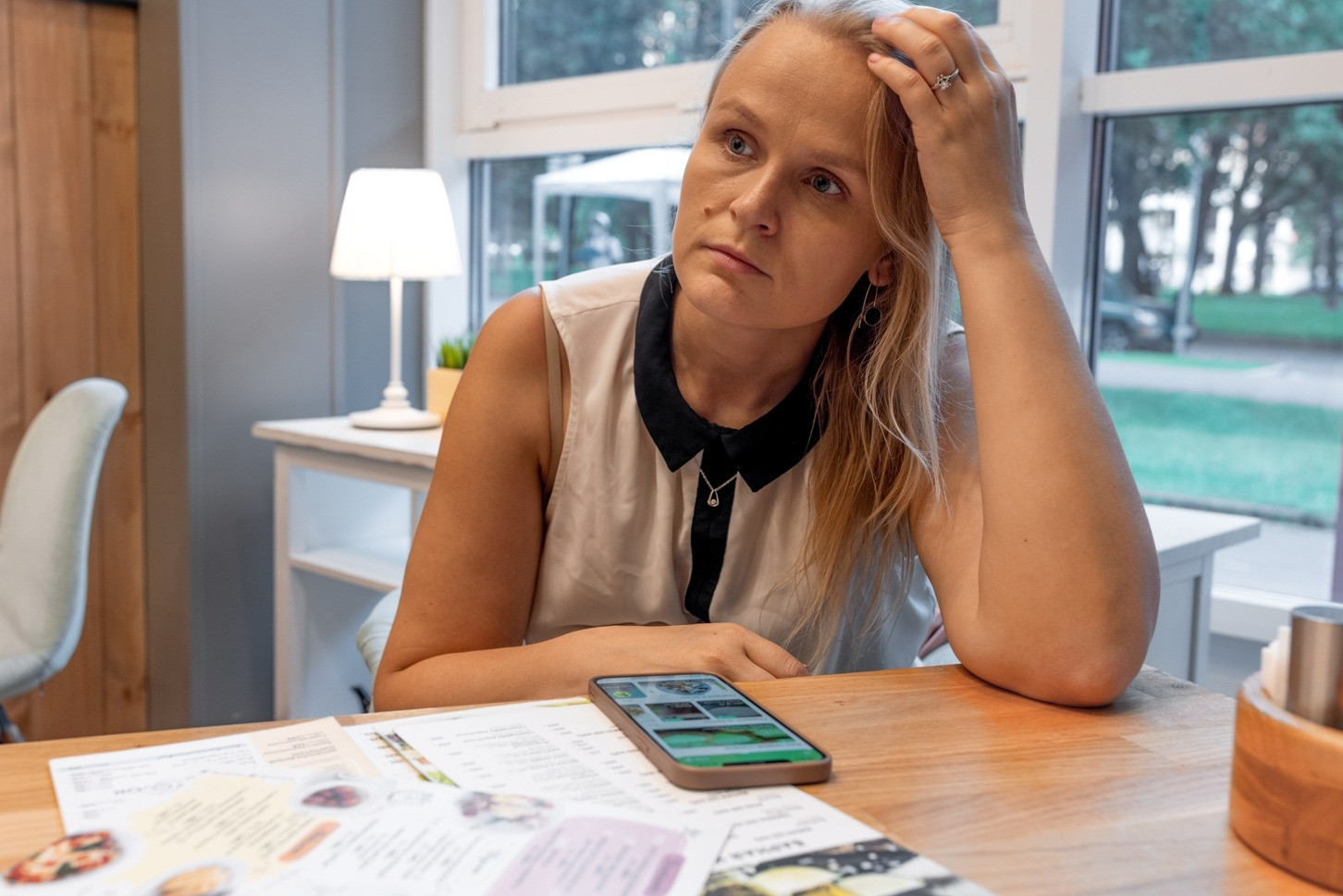 Woman sitting at a table looking thoughtful while recalling a memory