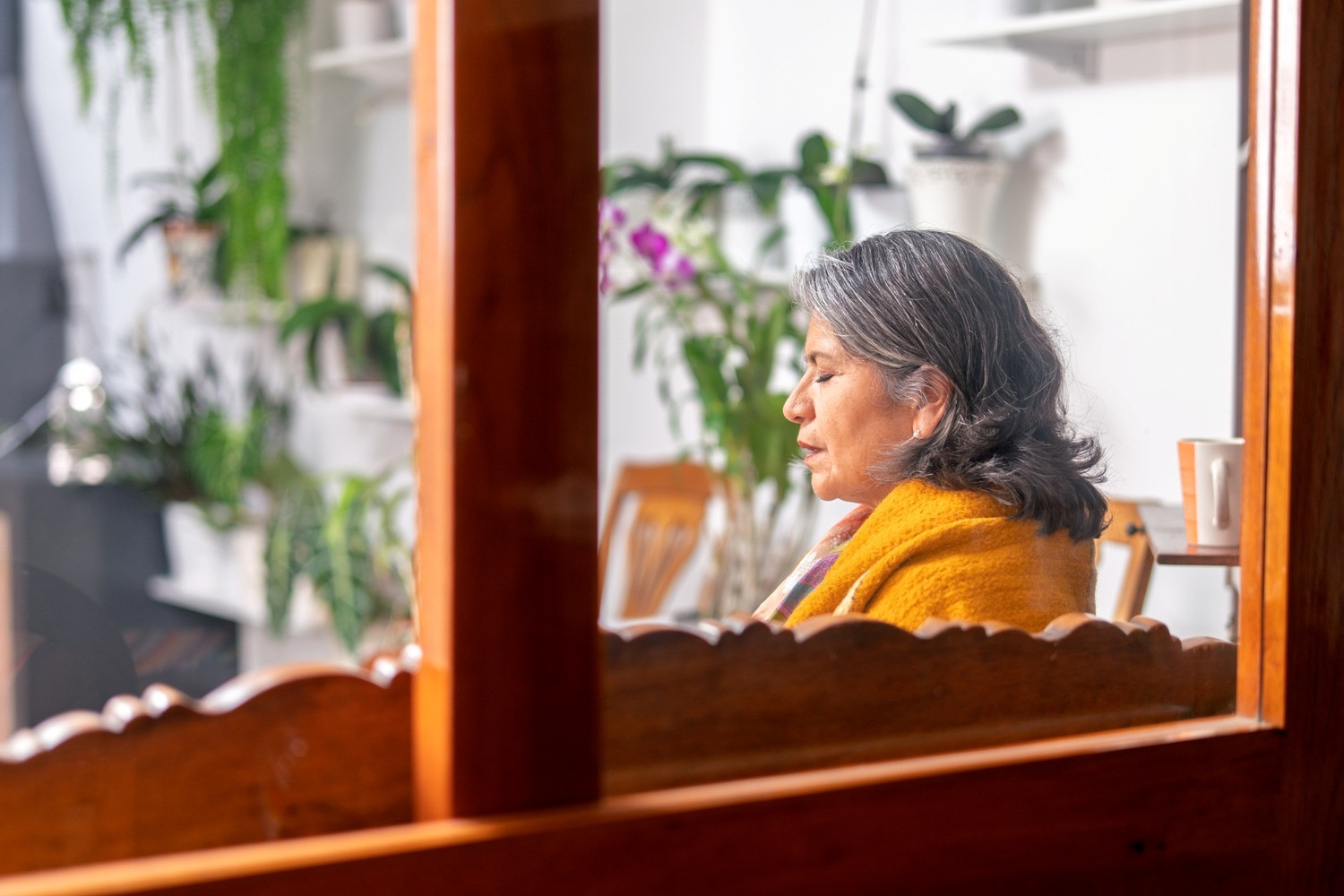 Woman with gray hair sitting quietly with her eyes closed after an EMDR session