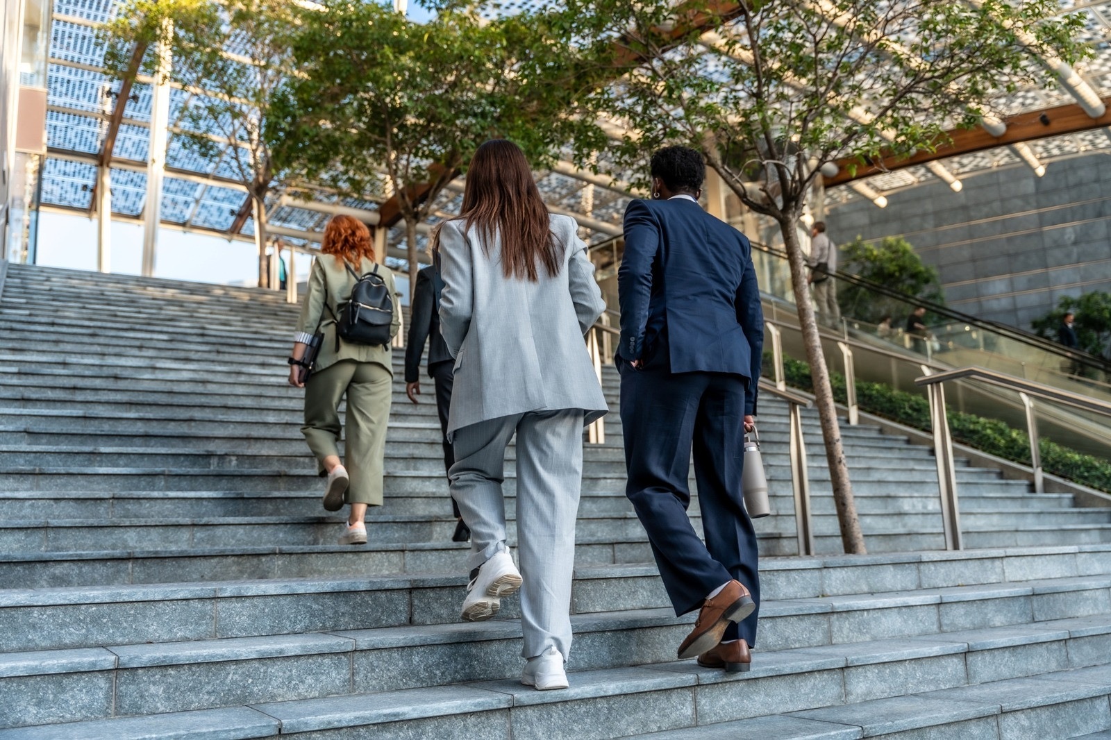 People walking up outdoor steps toward a modern building, representing progress and gradual changes between EMDR sessions.