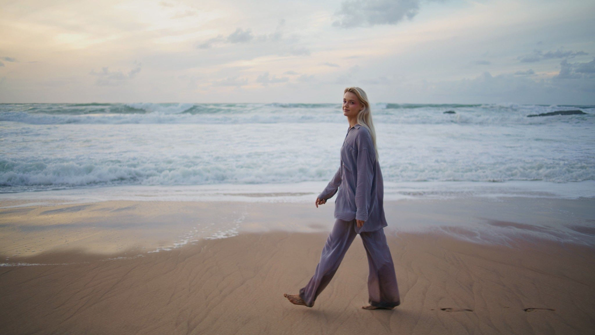 Woman walking along the beach near the ocean