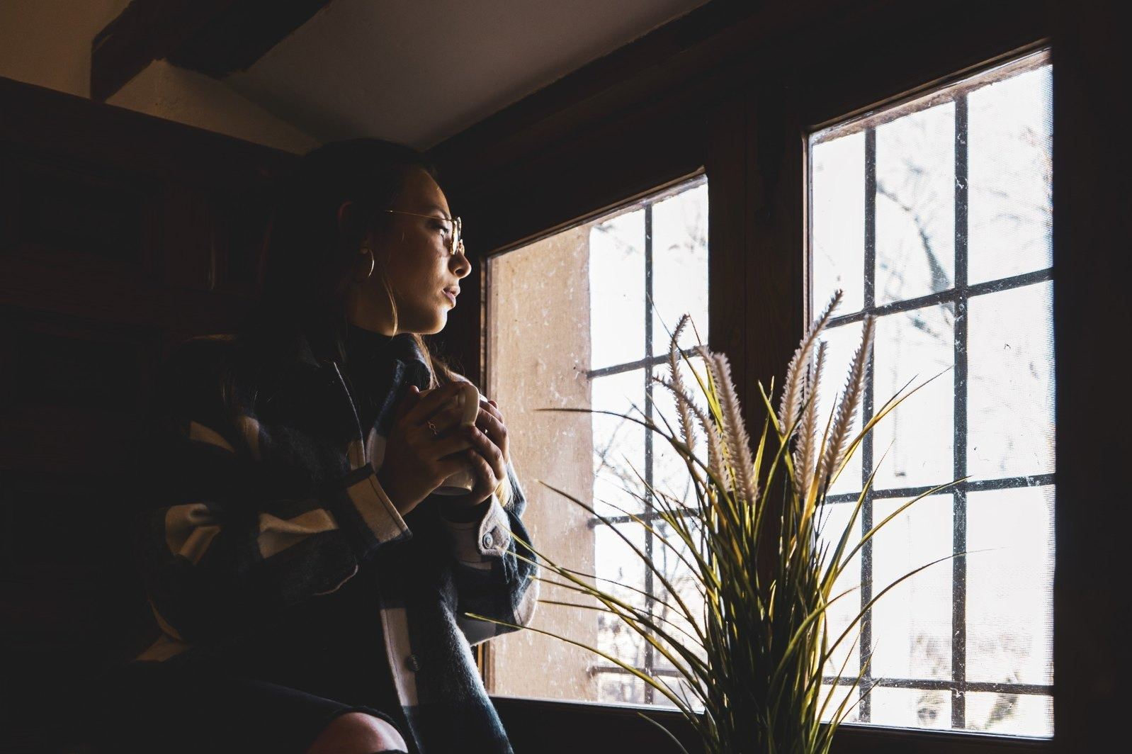 Woman relaxing on a sofa at home while holding a cup