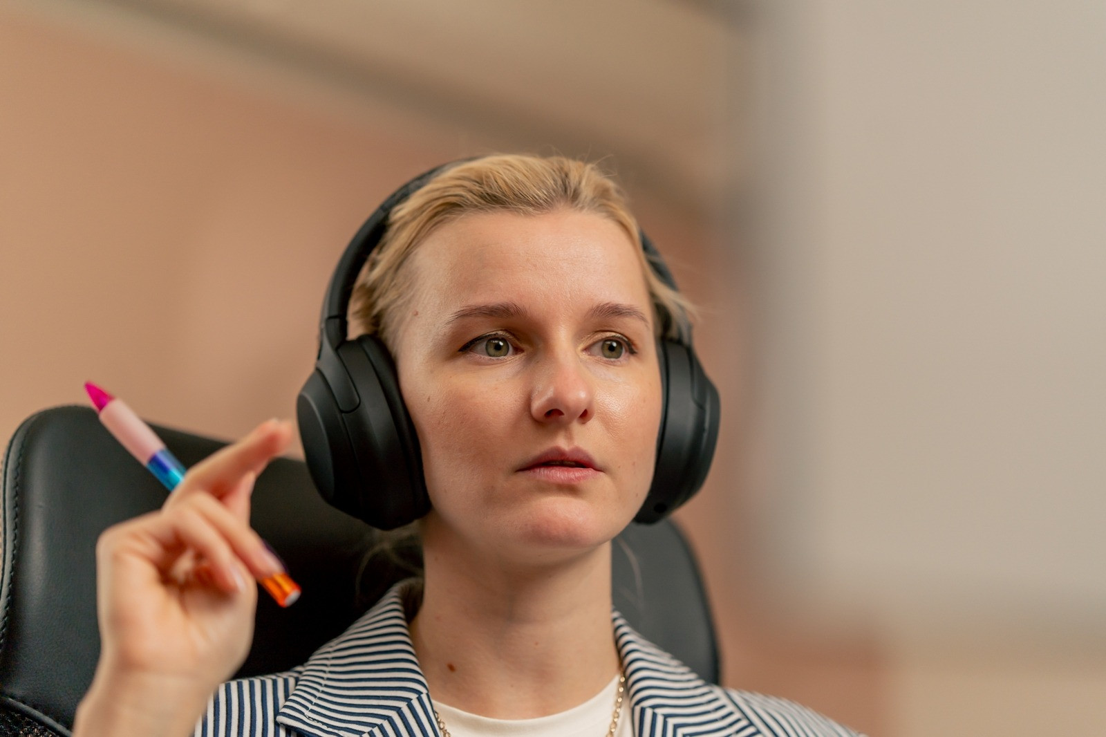 Woman wearing headphones and holding a pen during a focused EMDR session