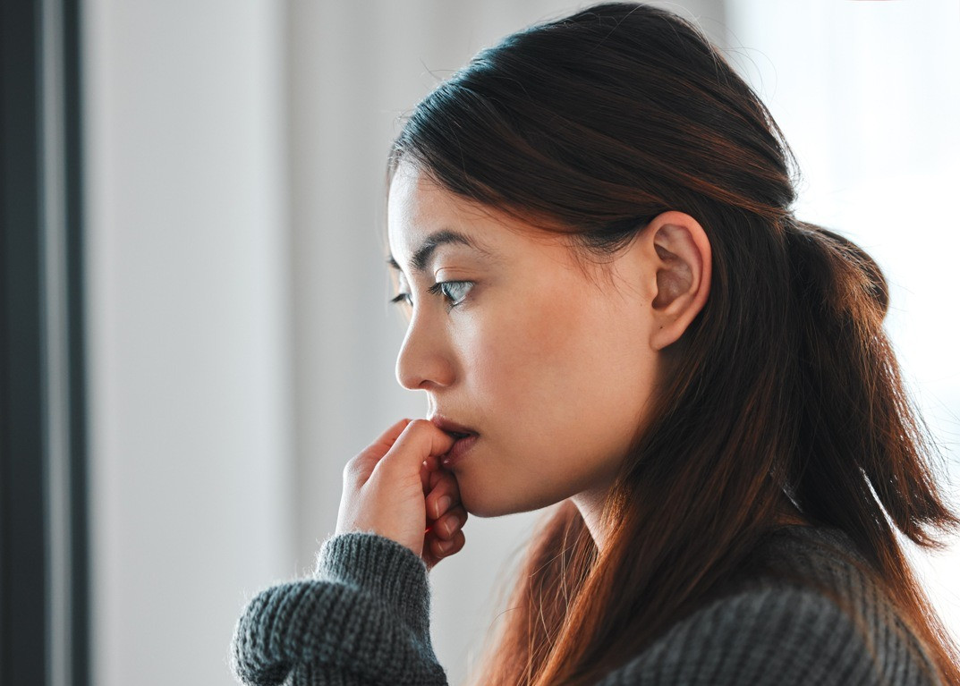 Woman looking thoughtful while reflecting on a belief during an EMDR session