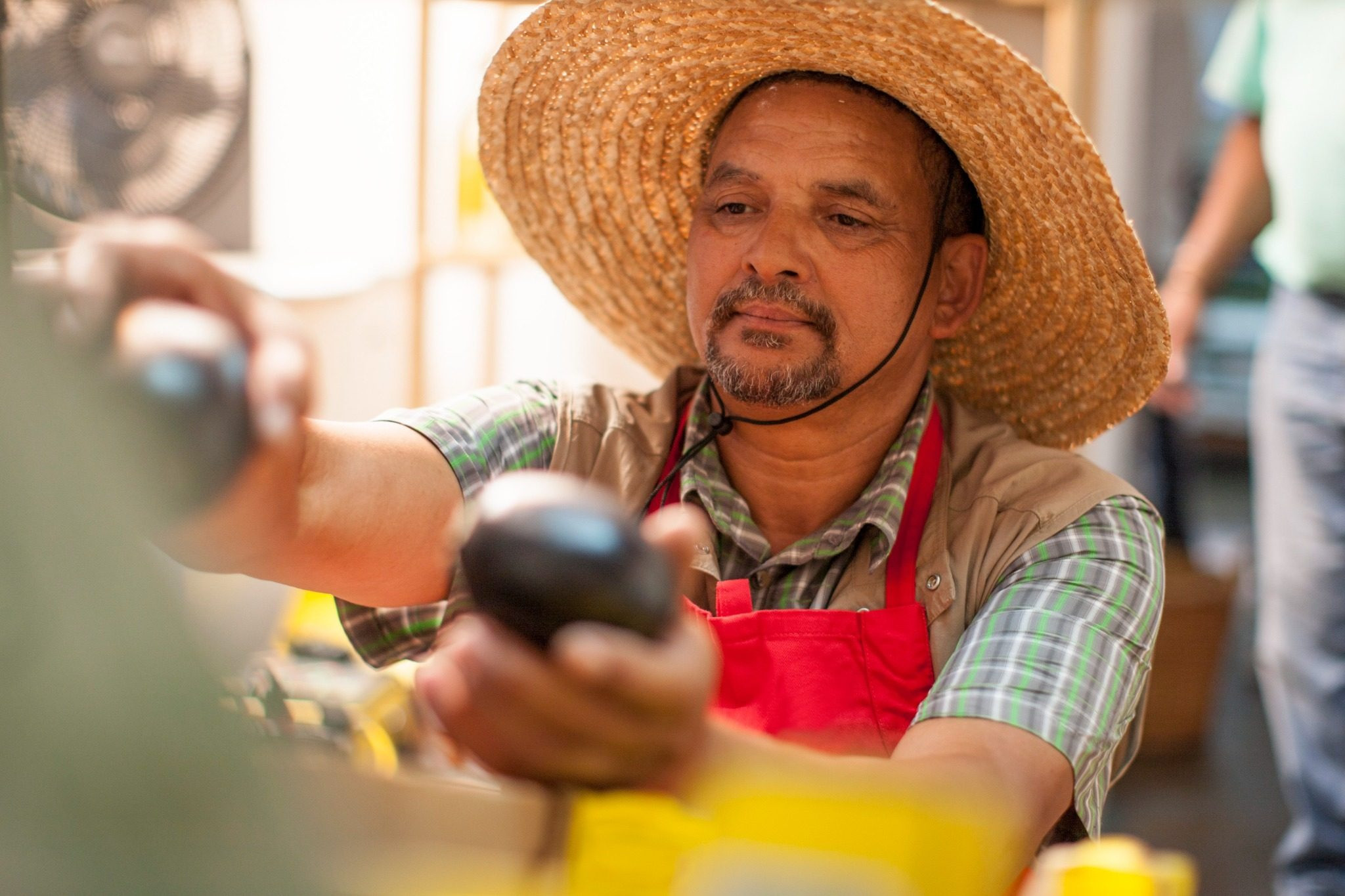 Man wearing a straw hat working at a counter