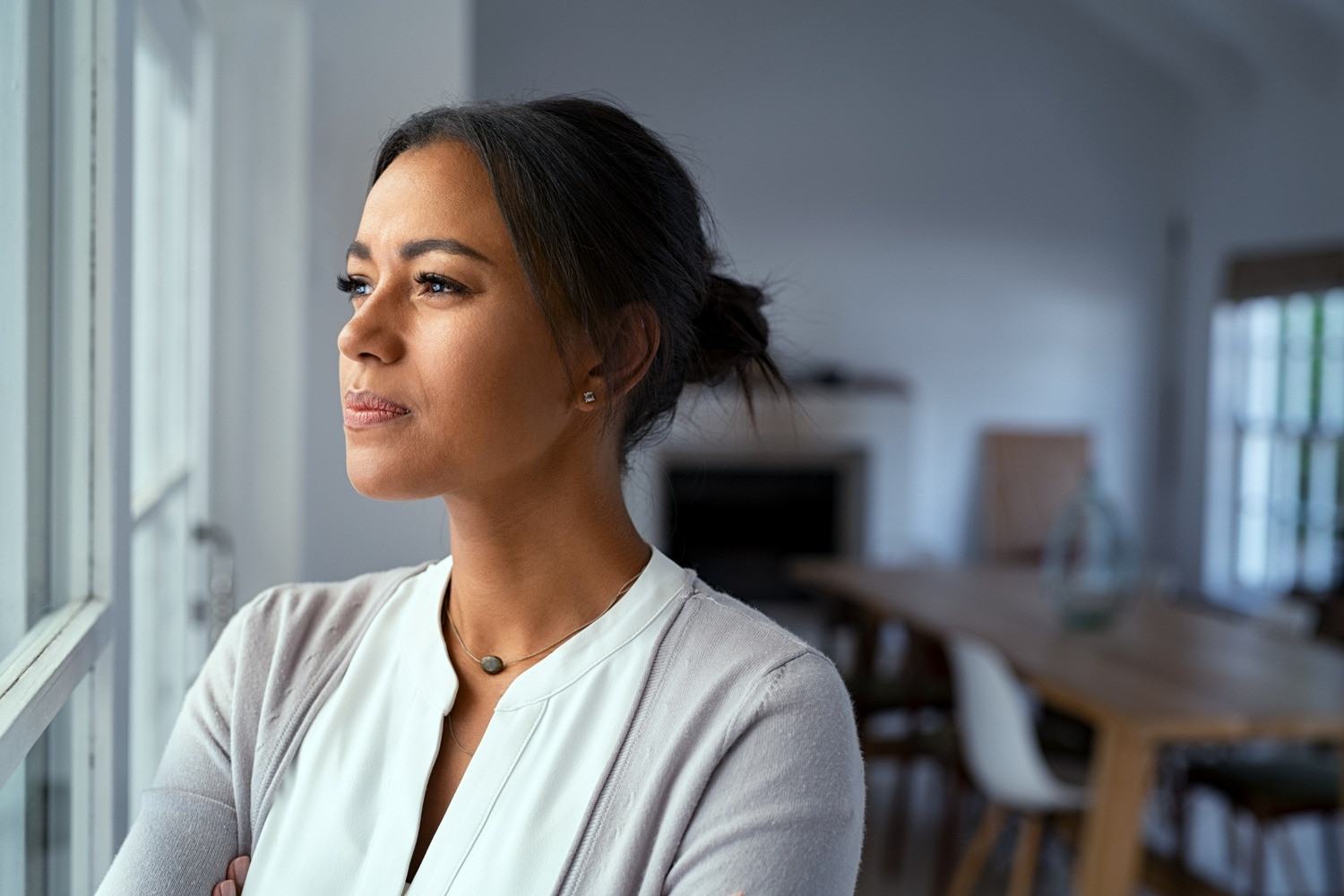 Woman looking thoughtfully out a window after an EMDR session