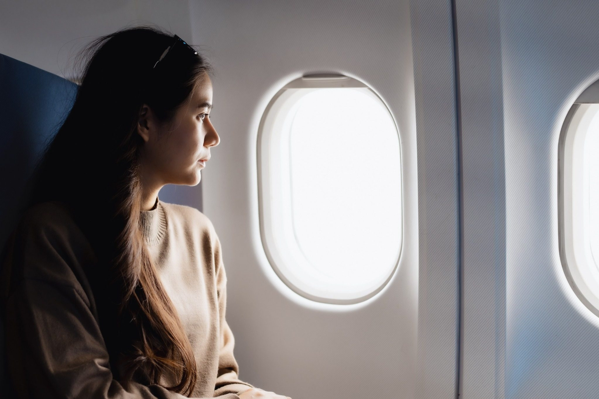 Woman sitting by an airplane window in a quiet seating area