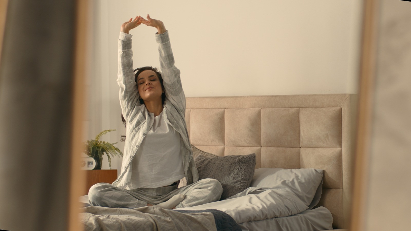 Woman stretching in bed after waking up, representing vivid dreams after an EMDR session.