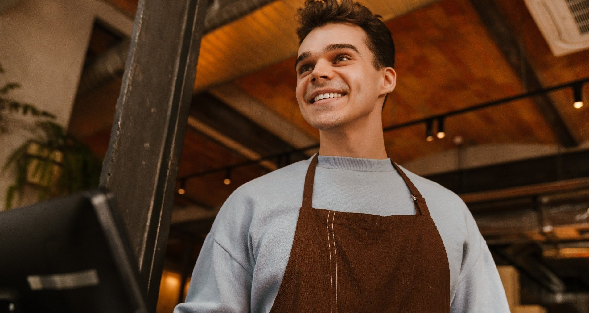 Smiling cafe worker standing at a counter