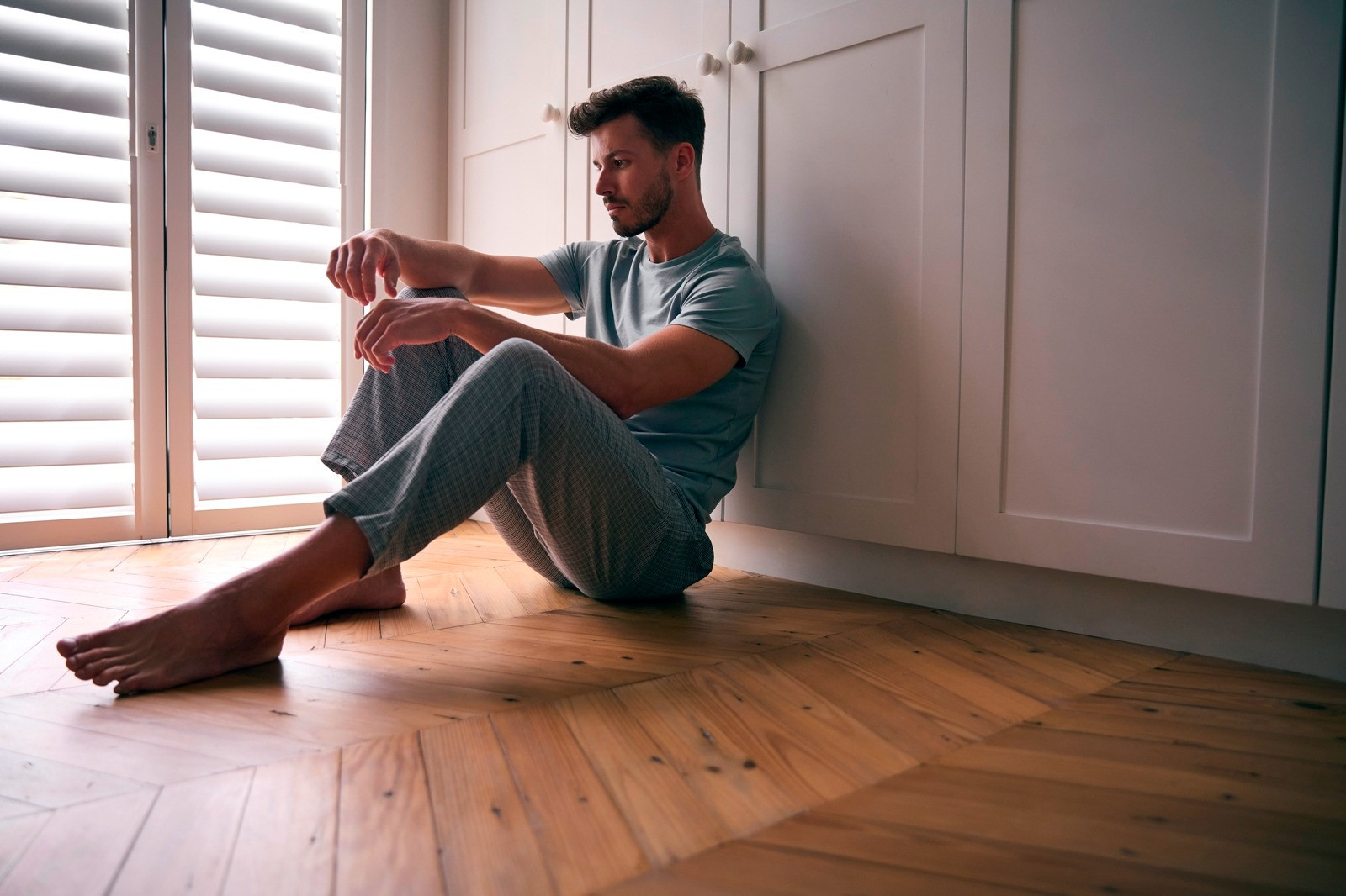 Man sitting quietly on the floor at home, representing a pause during a self-guided EMDR session.