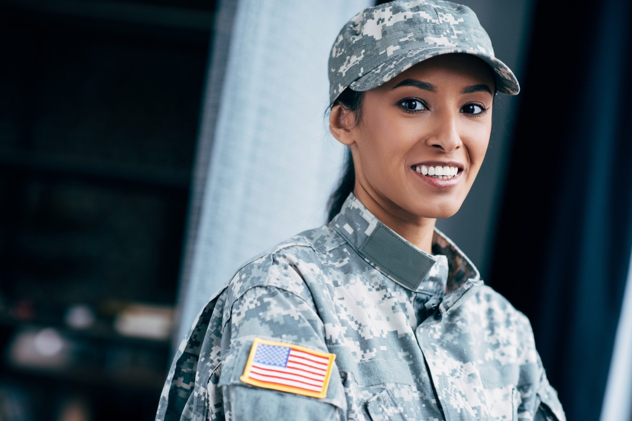 Smiling woman in military uniform standing indoors